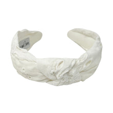 Load image into Gallery viewer, White headband with intricate white floral embroidery, displayed in a side view. The soft texture and elegant design convey a stylish, timeless appeal.