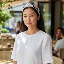 Load image into Gallery viewer, Woman wearing a white dress with a floral headband in an outdoor setting