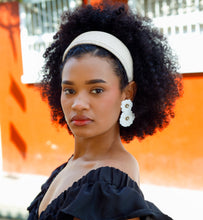 Load image into Gallery viewer, Woman wearing a black off-shoulder top and white floral earrings with a white background