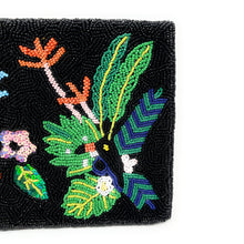 Load image into Gallery viewer, Fashion portrait featuring a woman holding a black floral beaded clutch decorated with vibrant tropical plants and handcrafted embroidery.