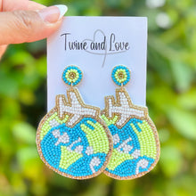 Load image into Gallery viewer, Beaded globe earrings with airplane and starfish detail in blue and green tones