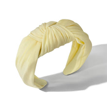 Load image into Gallery viewer, A pale yellow fabric headband with a knotted twist detail, displayed on a clean white background with a soft shadow.