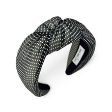 Load image into Gallery viewer, A fabric headband with a knotted bow detail, featuring a black and white polka dot pattern, shown on a plain white background.