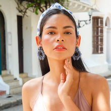 Load image into Gallery viewer, A model showcasing stunning blue earrings in a stylish outfit.