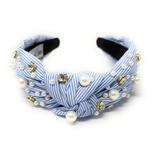 Load image into Gallery viewer, A blue and white striped headband adorned with pearls and gold beads. It features a knot design, creating an elegant and stylish accessory.