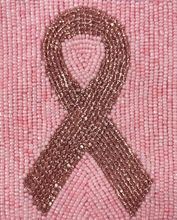 Load image into Gallery viewer, A close-up of a pink beaded ribbon patch on a textured pink fabric background.