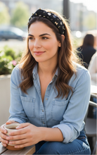 Load image into Gallery viewer, A woman sitting at an outdoor cafe, holding a cup of coffee, with a relaxed expression.