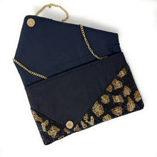 Load image into Gallery viewer, Chic black clutch bag with leopard print detailing and a gold chain strap.