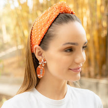 Load image into Gallery viewer, rendy orange headband paired with bold earrings on a woman outdoors.