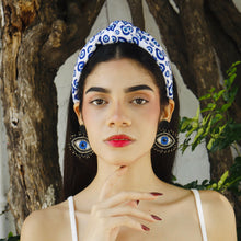 Load image into Gallery viewer, Portrait of a young woman with striking earrings and a fashionable headband.