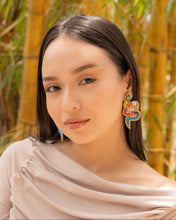 Load image into Gallery viewer, Model showcasing colorful earrings against a bamboo backdrop.
