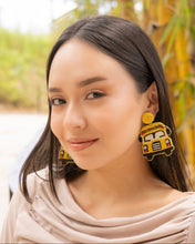 Load image into Gallery viewer, A close-up of a woman wearing colorful school bus earrings in a natural setting.