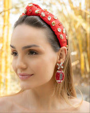 Load image into Gallery viewer, Close-up of a woman wearing a stylish Football red headband adorned with jewels and matching earrings.
