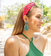 Load image into Gallery viewer, Close-up of a woman with elegant earrings and a pink headband in a natural setting.