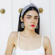 Load image into Gallery viewer, A chic woman wearing white apparel and eye-catching jewelry, exuding confidence.