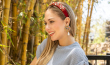 Load image into Gallery viewer, Close-up of a red elegant headband paired with a blue top and colorful earrings.