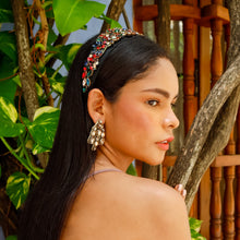 Load image into Gallery viewer, A woman showcasing a colorful headband and stylish earrings amidst lush greenery.
