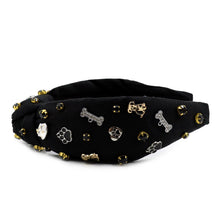 Load image into Gallery viewer, An embellished black fabric headband with unique charms and golden accents.