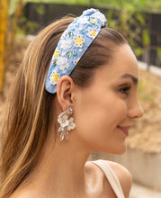Load image into Gallery viewer, A woman wearing a blue floral headband and elegant floral earrings in a natural outdoor setting.