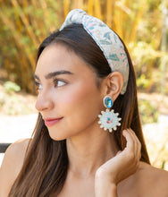 Load image into Gallery viewer, Close-up of a young woman wearing a floral headband and statement earrings in a natural setting.