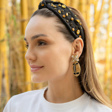 Load image into Gallery viewer, Elegant gold beaded football earrings worn by a woman