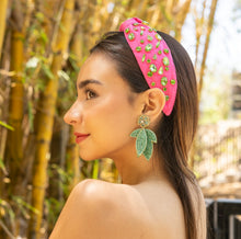 Load image into Gallery viewer, Stylish leaves earrings worn by a woman in a vibrant setting.