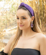 Load image into Gallery viewer, Stylish purple football earrings worn by a model outdoors.