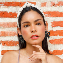 Load image into Gallery viewer, Elegant headshot of a model showcasing a fashionable look with a headband and earrings.
