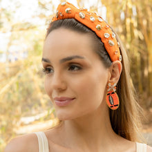 Load image into Gallery viewer, A woman wearing a stylish orange headband adorned with jewels and matching earrings in a natural outdoor setting.