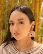 Load image into Gallery viewer, Close-up portrait of a woman wearing stylish pink earrings in a natural setting.
