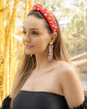 Load image into Gallery viewer, A woman wearing a stylish red headband adorned with decorative elements.