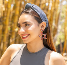 Load image into Gallery viewer, A model showcasing vibrant star earrings and a striped headband in a sunny outdoor setting.