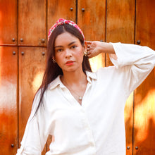 Load image into Gallery viewer, A stylish woman with a colorful headband posing against a wooden background.