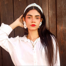 Load image into Gallery viewer, An elegant woman showcasing her accessories, including a necklace and earrings, in a natural pose.