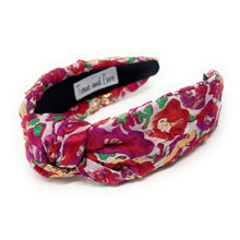 Load image into Gallery viewer, Floral patterned headband with a brand label on a white background