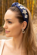 Load image into Gallery viewer, A woman wearing a stylish navy headband with star embellishments.