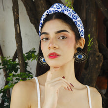 Load image into Gallery viewer, Trendy accessories including eye earrings and a stylish headband on a young woman.
