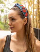 Load image into Gallery viewer, A woman wearing a stylish beaded headband with red embellishments in a natural setting.