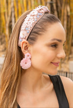 Load image into Gallery viewer, A woman wearing a floral headband and pink flower earrings, showcasing a stylish look