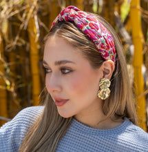 Load image into Gallery viewer,  Woman wearing a floral headband and gold flower earrings in a sunny outdoor setting.
