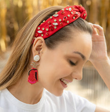 Load image into Gallery viewer, A smiling woman showcasing a fashionable red headband and statement earrings.