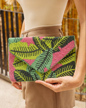 Load image into Gallery viewer, A stylish tropical leaf clutch bag held by a woman.