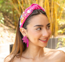 Load image into Gallery viewer, A woman wearing a vibrant pink headband with intricate designs, showcasing her style.