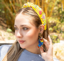Load image into Gallery viewer, A stylish woman with a yellow headband and vibrant beaded earrings, captured in a sunny outdoor setting.
