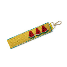 Load image into Gallery viewer, Hand beaded watermelon wristlet keychain featuring three colorful watermelon slices on a mustard yellow beaded strap with turquoise trim. Includes a gold-tone lobster clasp and soft wrist loop, perfect for carrying keys, key fobs, ID badges, or small accessories.