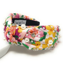 Load image into Gallery viewer, Side profile of a woman styling a multicolor floral headband with pearl embellishments and layered white flower earrings.