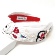 Load image into Gallery viewer, White nurse-themed headband with embroidered medical icons and playful red heart accents styled outdoors.