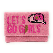 Load image into Gallery viewer, Woman holding a pink hand-beaded clutch featuring the phrase “Let’s Go Girls” and a cowgirl hat design with gold accents.