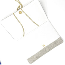 Load image into Gallery viewer, White envelope clutch with a detachable gold chain strap and a sparkling silver beaded trim along the flap edge.