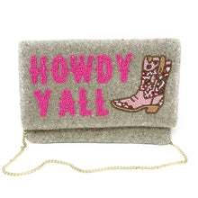 Load image into Gallery viewer, Model in a black dress carrying a handmade beaded envelope clutch that reads “Howdy Y’all” in vibrant pink beads.